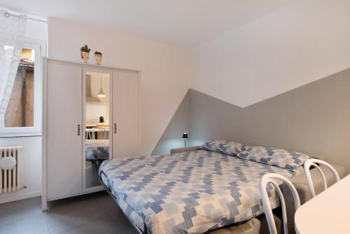 a bedroom with a bed with a checkered blanket at La filanda in Abbadia Lariana