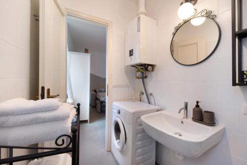 a white bathroom with a washing machine and a sink at La filanda in Abbadia Lariana