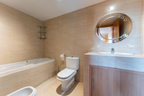 a bathroom with a toilet and a sink and a mirror at Las Terrazas in La Cala de Mijas