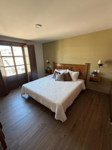 a bedroom with a large bed with white sheets and pillows at Spacious house just steps from the cathedral in Morelia