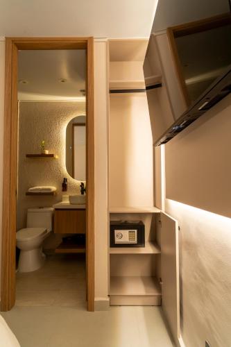 a bathroom with a toilet and a sink and a mirror at Bruma Verde Casa Hotel in Medellín