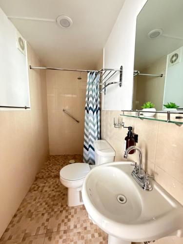 a bathroom with a sink and a toilet and a mirror at Spacious house just steps from the cathedral in Morelia