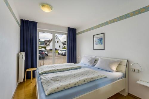 a bedroom with a bed and a window at Fewo Ricken am Kurpark in Willingen