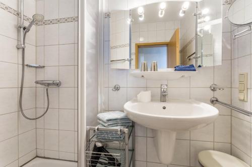 a white bathroom with a sink and a shower at Fewo Ricken am Kurpark in Willingen