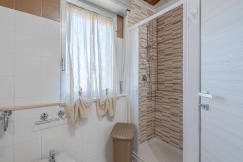 a bathroom with a shower and a toilet and a window at Le tre pigne in Floridia