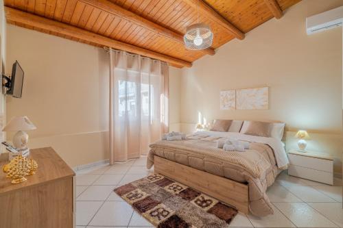 a bedroom with a large bed and a wooden ceiling at Le tre pigne in Floridia