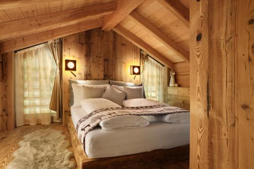 a bedroom with a large bed in a log cabin at Luxury Chalet Giulia in Torcegno