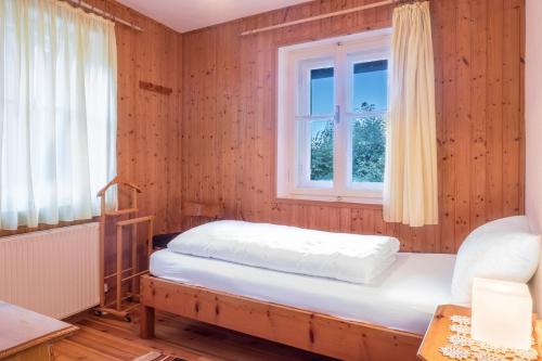 a bedroom with a bed and a window at Ferienhaus Fingerhut in Eggen