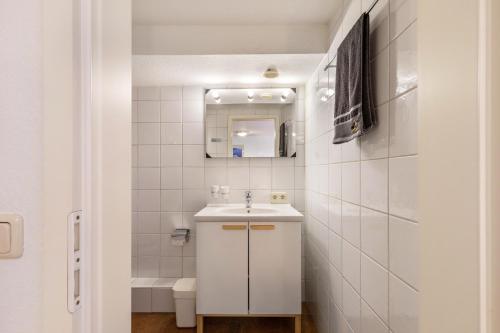 a white bathroom with a sink and a mirror at Spessartruhe in Linsengericht