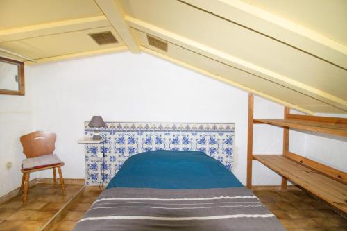 ein kleines Schlafzimmer mit einem Bett und einem Stuhl in der Unterkunft Le Sei in Appietto