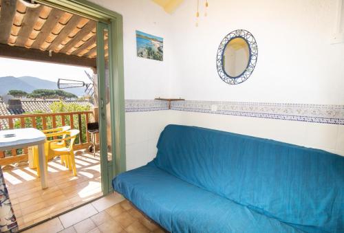 eine blaue Couch in einem Zimmer mit Balkon in der Unterkunft Le Sei in Appietto
