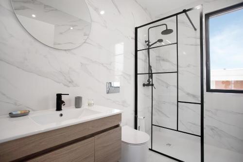 a white bathroom with a shower and a sink at Villa Atlantic View in Salir de Porto