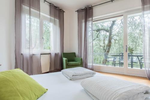 a bedroom with a bed and a chair and a window at appartamento casa stefi n1 in Malcesine