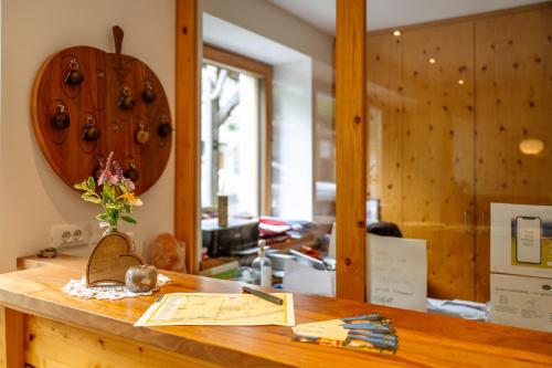 a wooden counter with a vase of flowers on it at Huberhof App Golden Delicious in Feldthurns