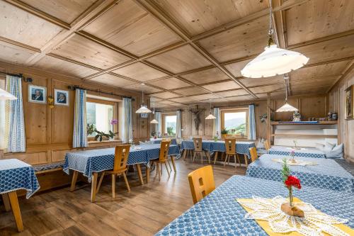 a dining room with blue tables and chairs at Huberhof App Golden Delicious in Feldthurns