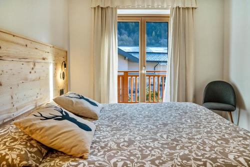 a bedroom with a large bed and a window at Condominio Lucia 7 Pinzolo in Pinzolo