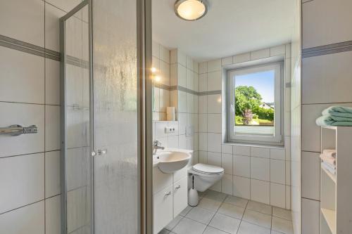 a bathroom with a sink toilet and a window at Ferienwohnung Hacke in Schmallenberg