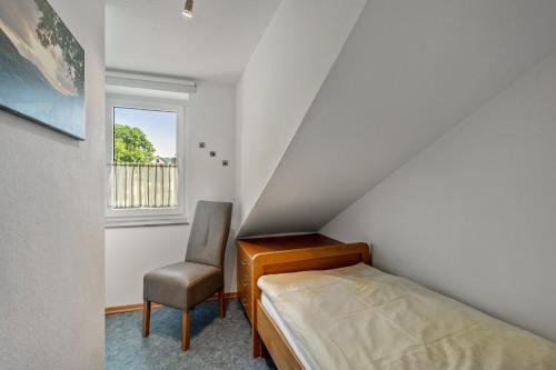 a small bedroom with a bed and a chair at Ferienwohnung Hacke in Schmallenberg