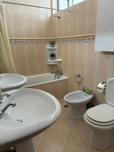 a bathroom with a sink and a toilet and a tub at Geninha Stay Aveiro in Aveiro