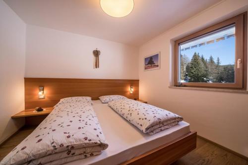 a bedroom with a bed and a window at Ferienwohnung Kratzberg Edelweiss in Avelengo