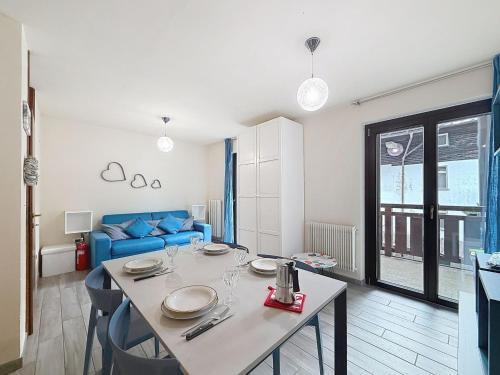 a living room with a table and a blue couch at Apartment Marmolada-13 by Interhome in Alba di Canazei