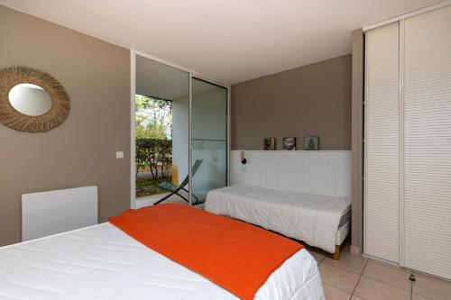 a bedroom with two beds and a mirror at Appartement Bisbau in Moliets-et-Maa