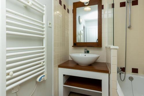 a bathroom with a sink and a shower and a mirror at Appartement Bisbau in Moliets-et-Maa