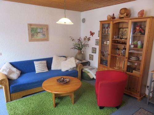 a living room with a blue couch and a red chair at Ferienwohnung Sternenhof in Breisach am Rhein
