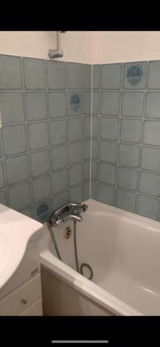 a bath tub with a faucet in a bathroom at Appt de montagne Araches in Arâches-la-Frasse