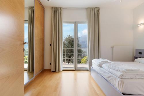a bedroom with a bed and a large window at Casa-lago suite 55 in Brenzone sul Garda