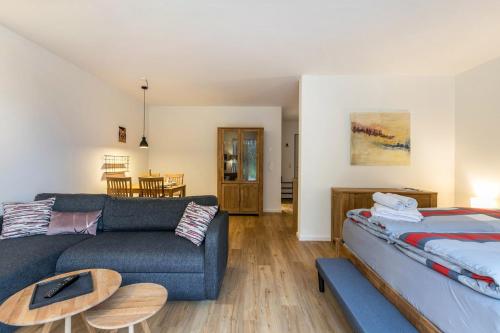 a living room with a couch and a bed at Willewatt Wohnung 1 in Husby