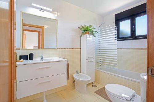 a bathroom with a sink and a toilet and a mirror at Encantadora Casa Tara in Lajares