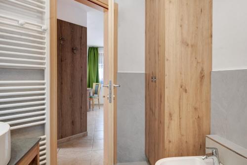 a bathroom with a toilet and a wooden door at Night and day 8 in Predazzo