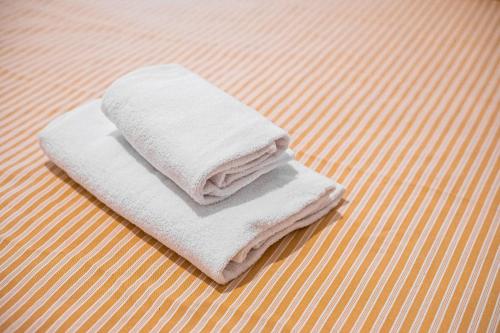 a stack of white towels sitting on a floor at La Capannuccia D in Ansedónia