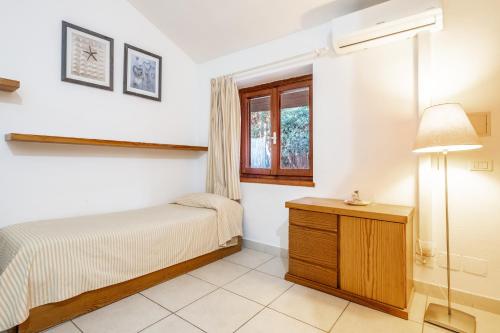 a bedroom with a bed and a window at La Capannuccia D in Ansedónia