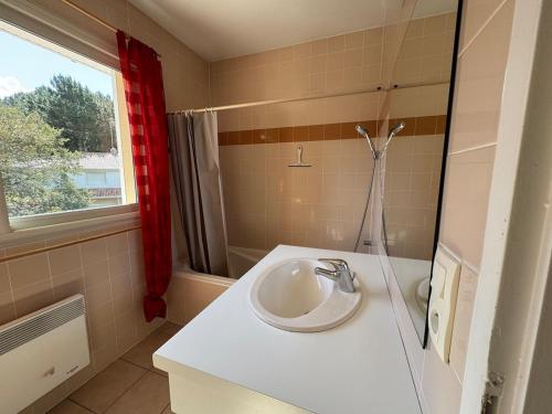a bathroom with a white sink and a window at Villa Casa Brisa, pour 6 voyageurs, proche des plages à 8 minutes en vélo in Capbreton