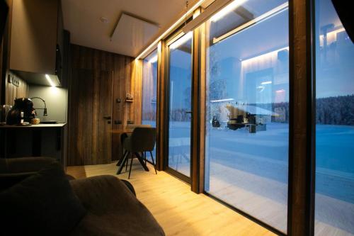 a living room with a view of a pool through sliding glass doors at Sonka Resort Mirror House with Lake View in Rovaniemi
