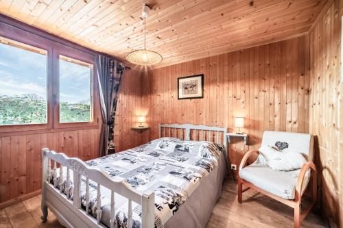 a bedroom with a bed and a chair at Chalet Phidel - 11 personnes in Bernex