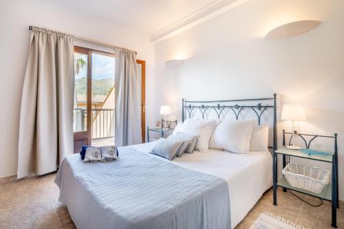 a bedroom with a large bed and a balcony at Ca Na Kika in Alcudia