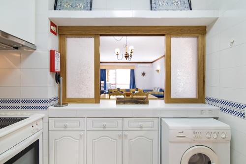 a kitchen with a washer and dryer in a room at T2 com piscina centro Vilamoura in Vilamoura