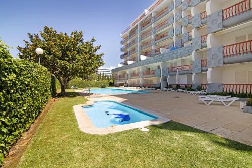 a swimming pool in front of a building at T2 com piscina centro Vilamoura in Vilamoura