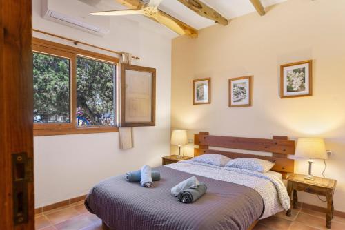 a bedroom with two beds and a window at Can Mussenya 1 in Illes Balears