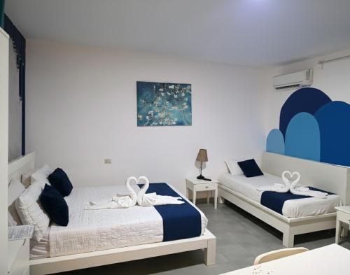 two beds in a room with blue and white at beautiful vacation Sol Caribe in Punta Cana