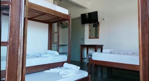 a room with two bunk beds and a television at Associação Sabesp Bertioga - SP in Bertioga