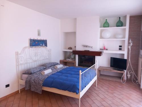 a bedroom with a blue bed and a fireplace at Villetta G in Senigallia