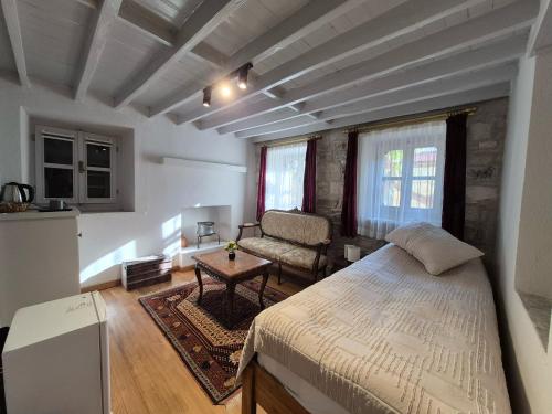 a bedroom with a large bed and a chair at Kavcıoğlu Rooms in Urla