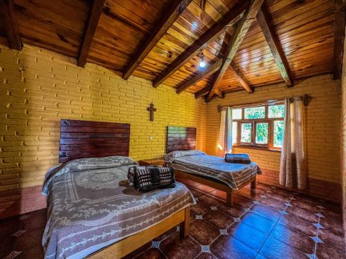 ein Schlafzimmer mit zwei Betten in einem Holzhaus in der Unterkunft Cabañas Lupita 31 in Mazamitla