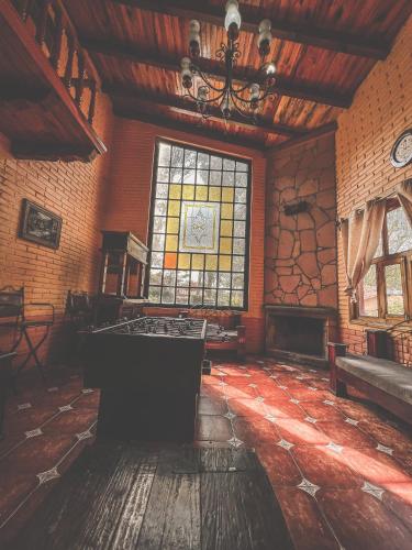ein großer Raum mit einem großen Fenster und einem Tisch in der Unterkunft Cabañas Lupita 31 in Mazamitla