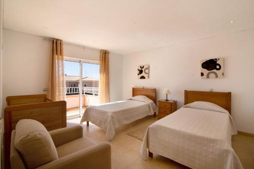 a bedroom with two beds and a balcony at Casa Tulipas in Loulé