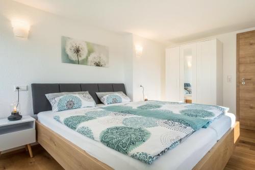 a bedroom with a bed with a blue and white comforter at Ferienwohnung Pusteblume in Neukirch